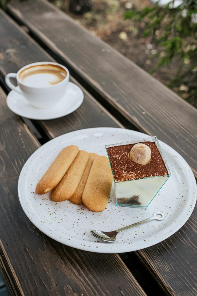 pexels-photo-4472870-4472870 Tiramisu dessert with ladyfingers and coffee on a rustic wooden table outdoors.
